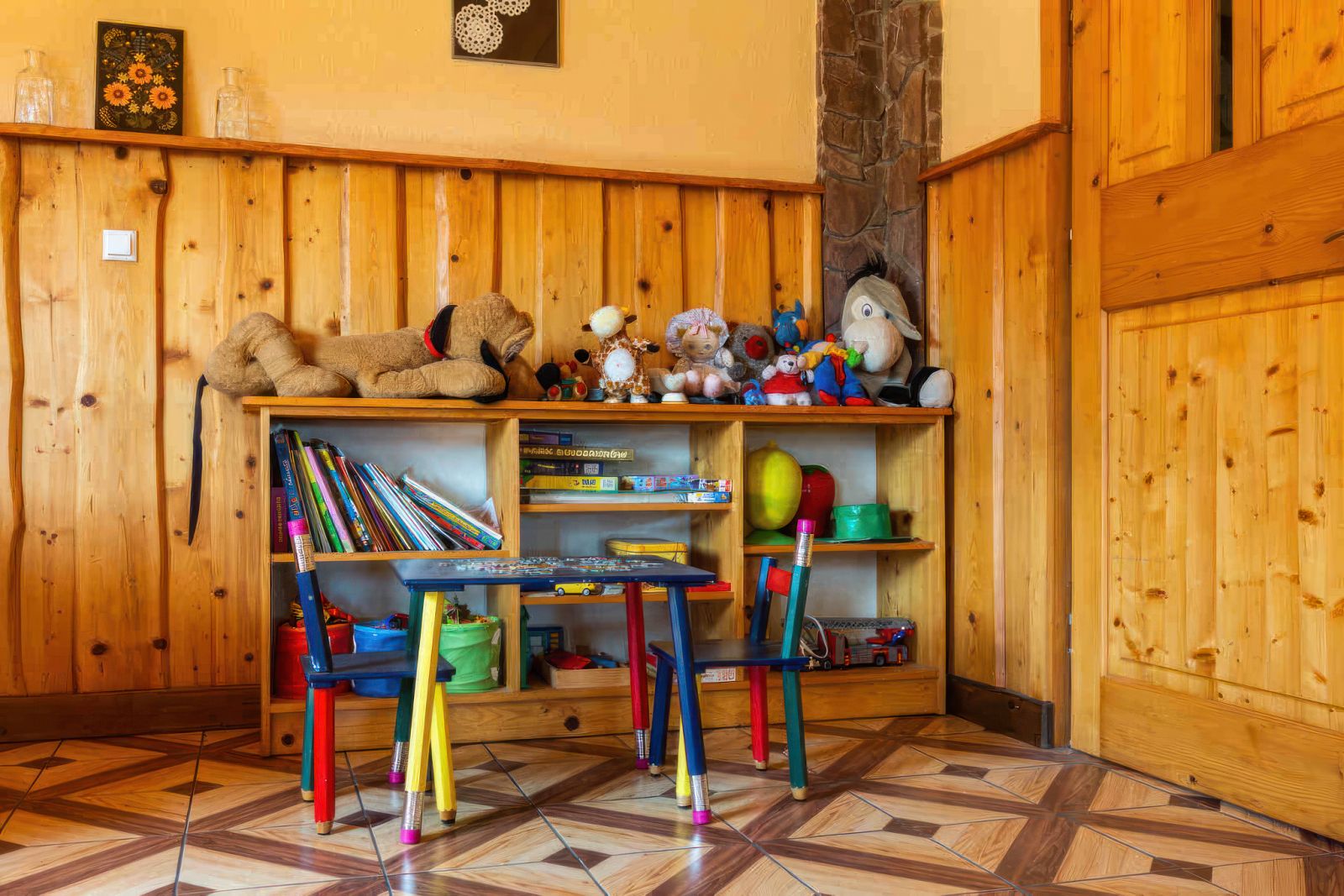 Sala zabaw dla dzieci w Willi OdNova z drewnianymi meblami, zabawkami i książkami