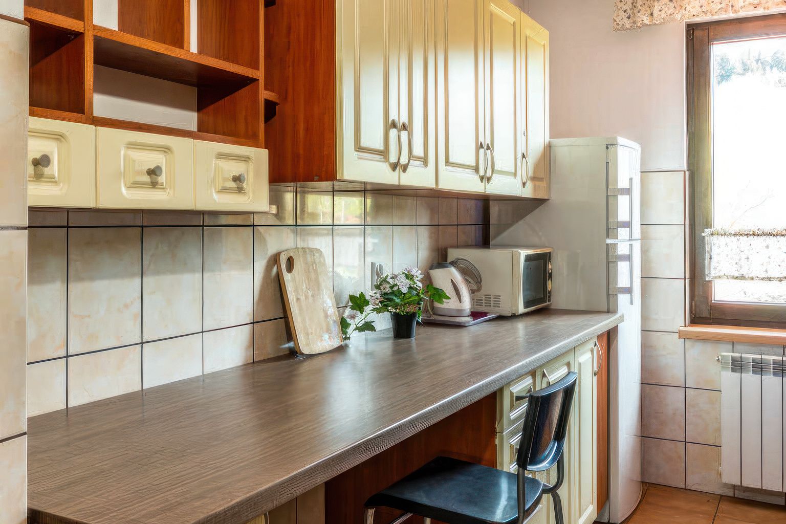 Funkcjonalna kuchnia Willi OdNova z drewnianymi szafkami, drewnianymi stołkami i oknem